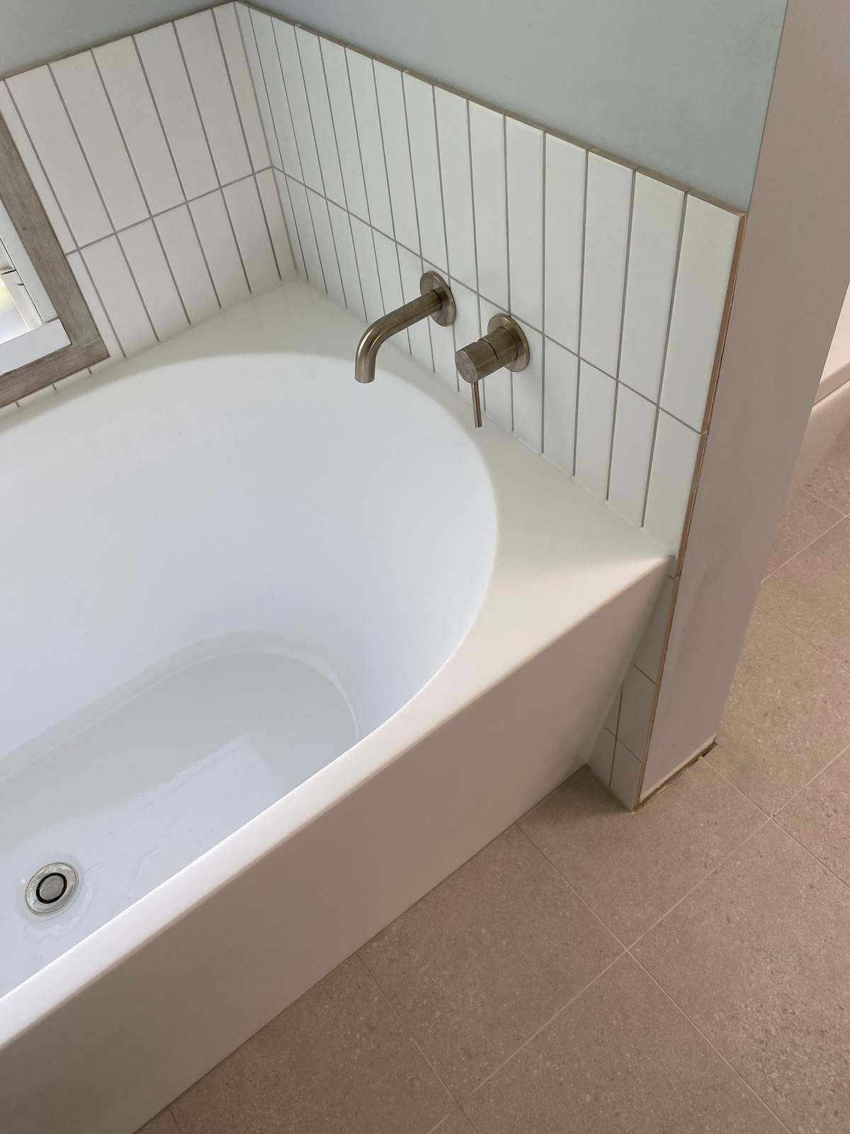 A Bathtub in a Bathroom With White Tiles on the Wall — Nick Hall Builder in Cooroy, QLD