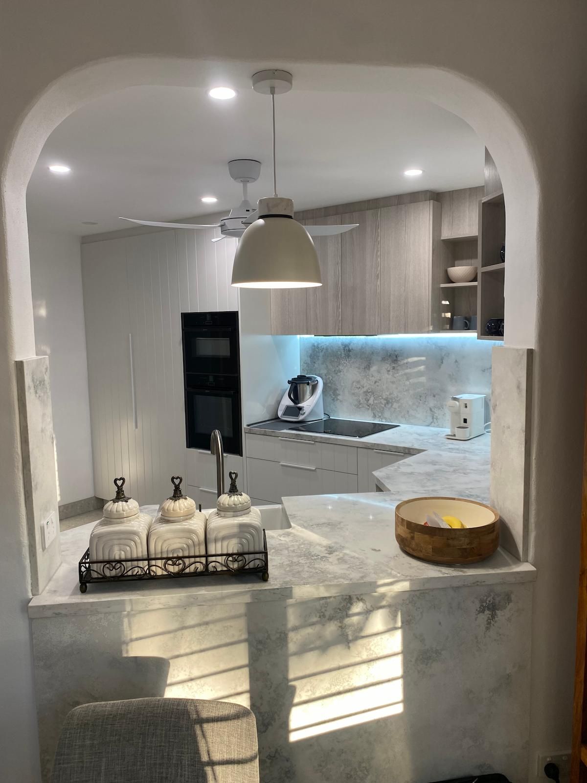 A Kitchen With White Cabinets, a Sink, and a Ceiling Fan — Nick Hall Builder in Cooroy, QLD