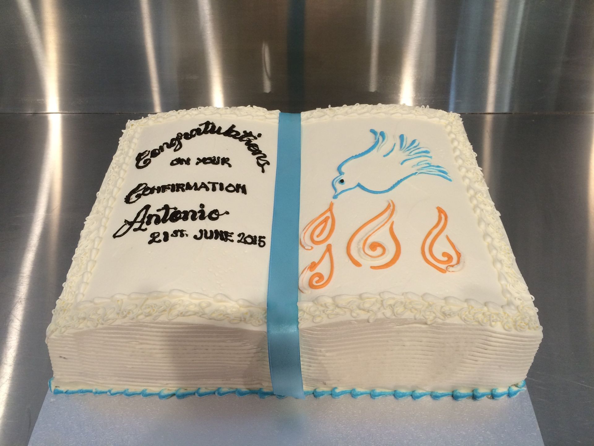 white confirmation book cake with blue bird