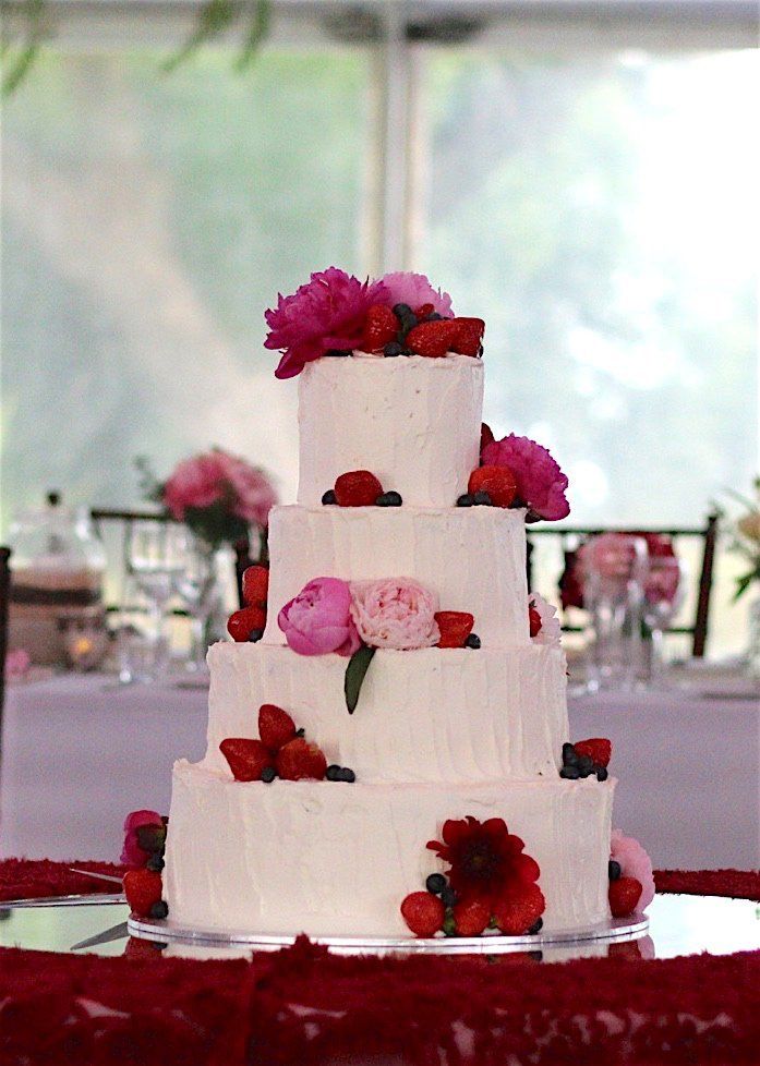 four level white cake with red roses strategically placed