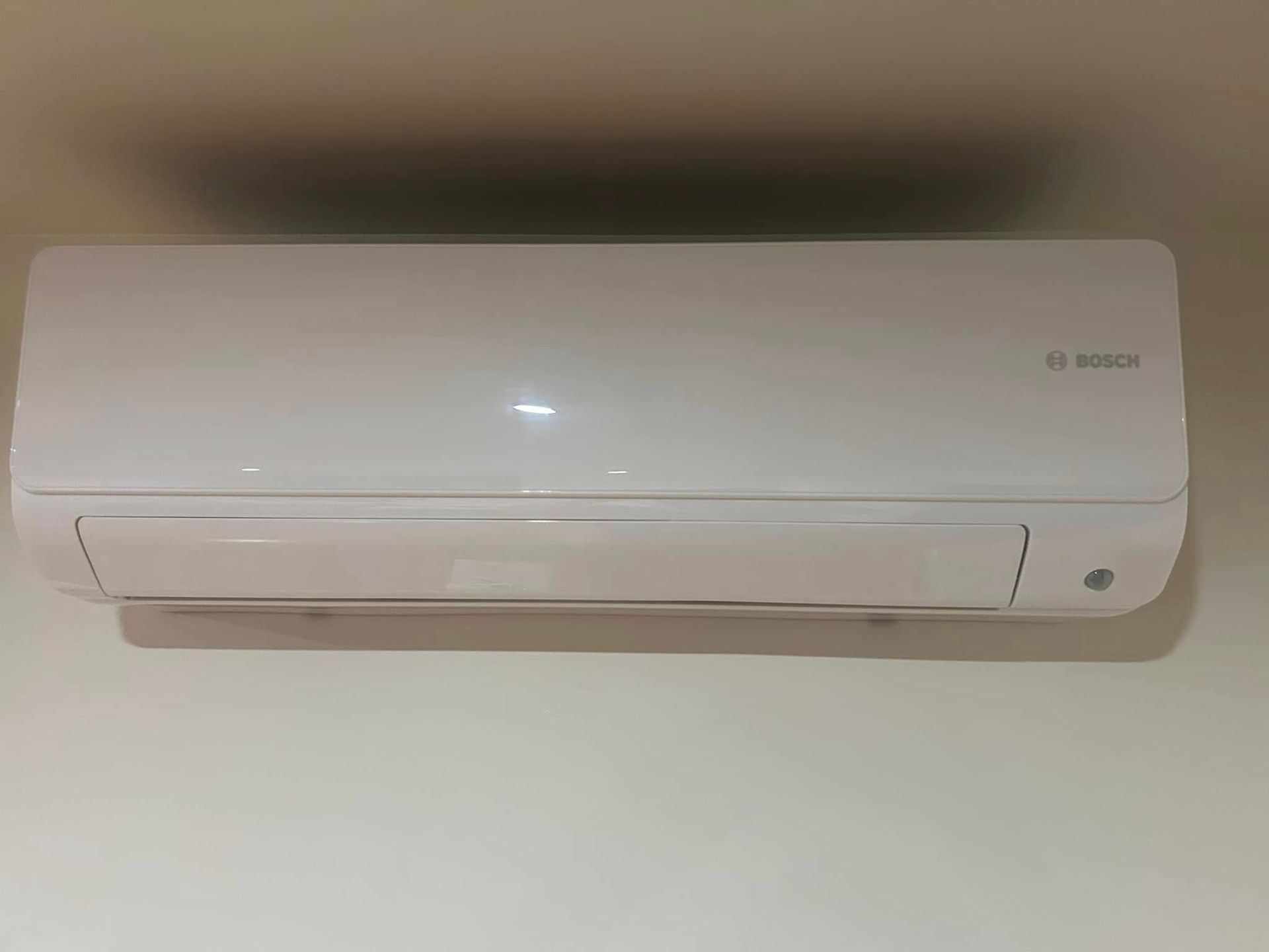 A white air conditioner is hanging on a wall.