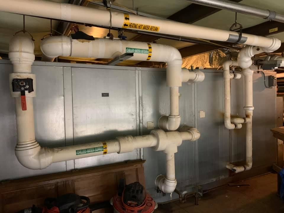 A bunch of pipes are hanging from the ceiling in a room.
