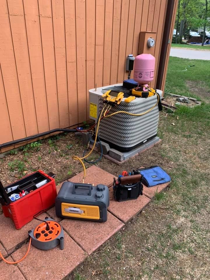 An air conditioner is being repaired on the side of a building.