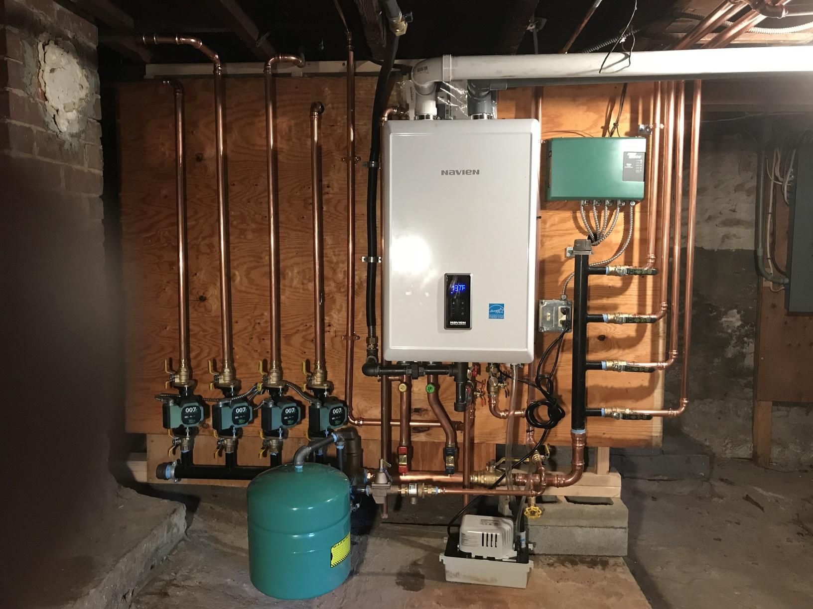 A water heater is installed in a basement with copper pipes