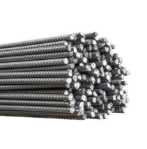 Pila de barras de refuerzo de acero, cilíndricas con superficies estriadas, color gris.