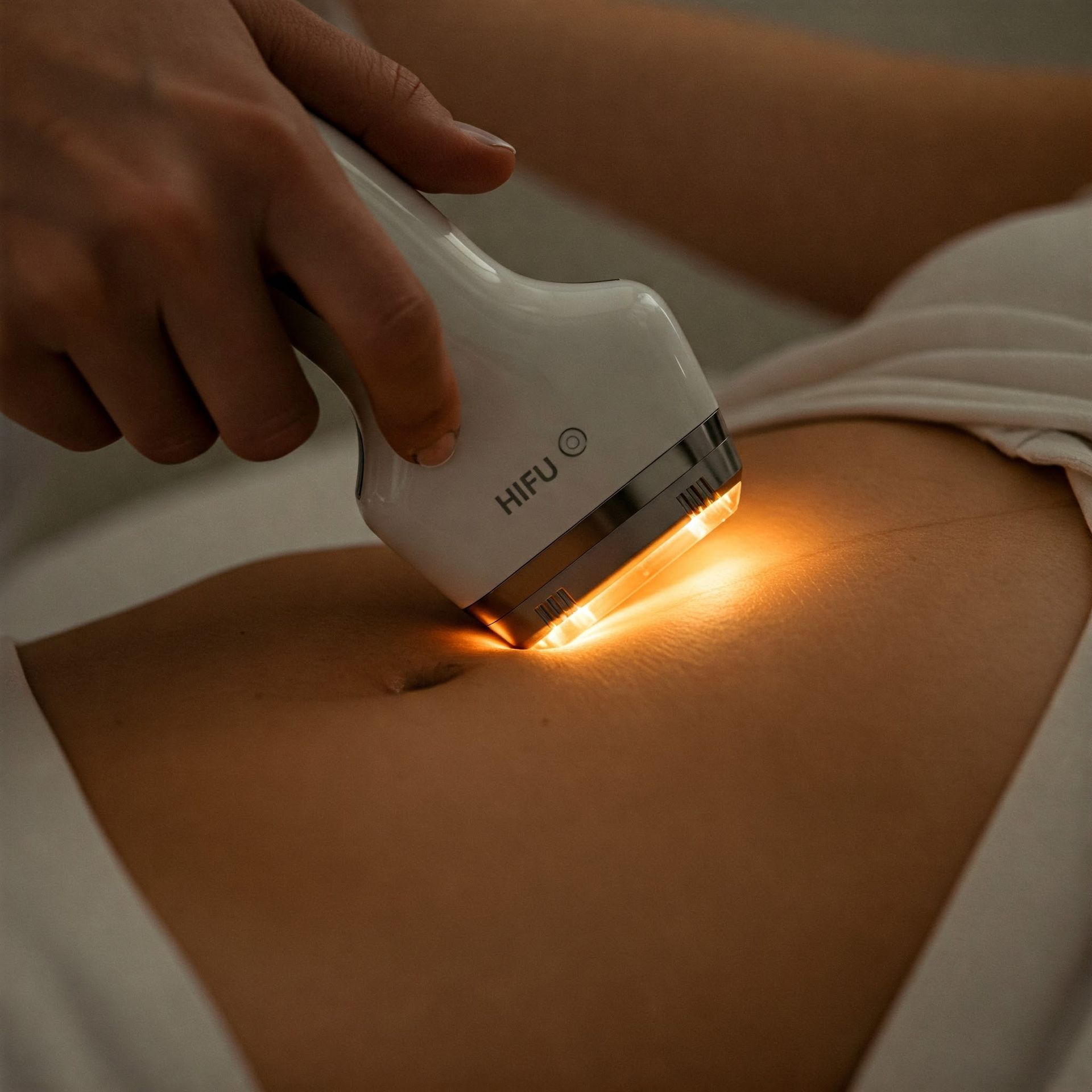A woman is getting a hifu treatment on her stomach.