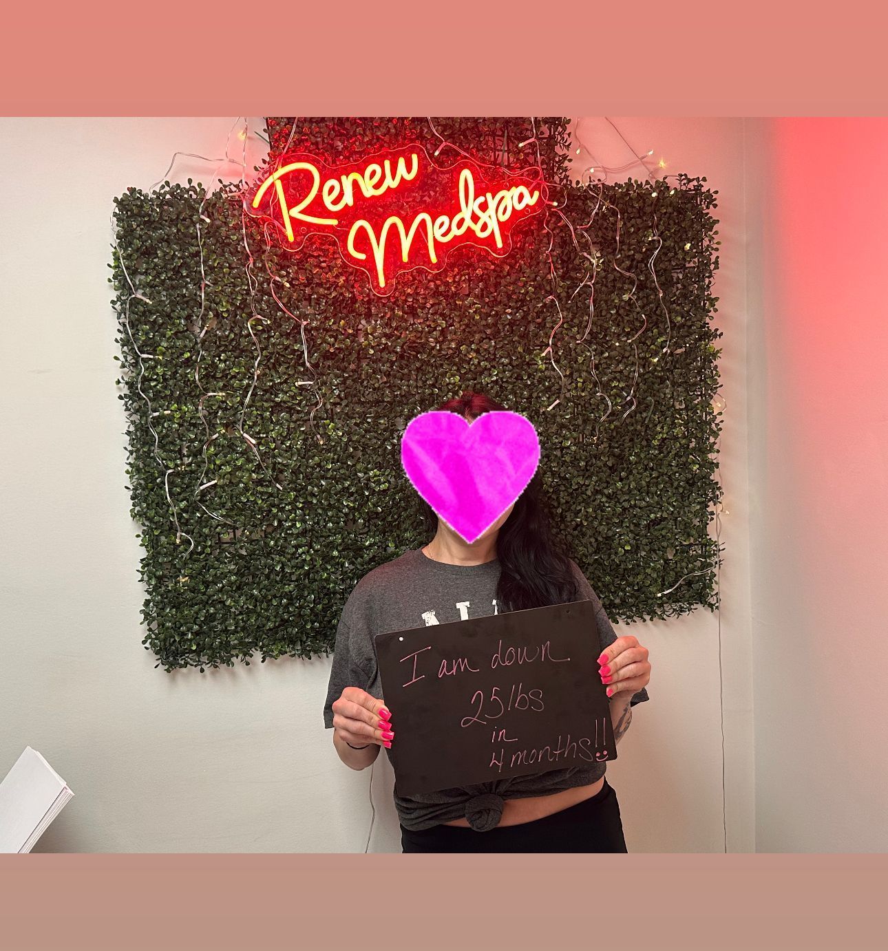 A woman is holding a sign in front of a neon sign that says renew medspa.