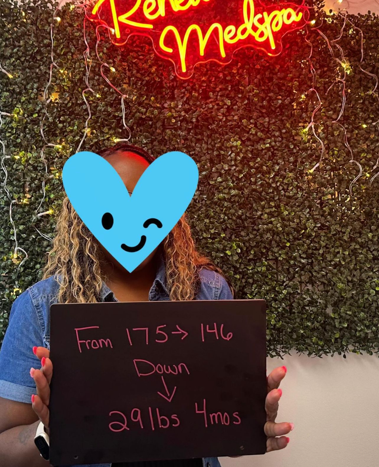 A woman is holding a sign that says from 175 to 146 down 29 lbs 4 mos