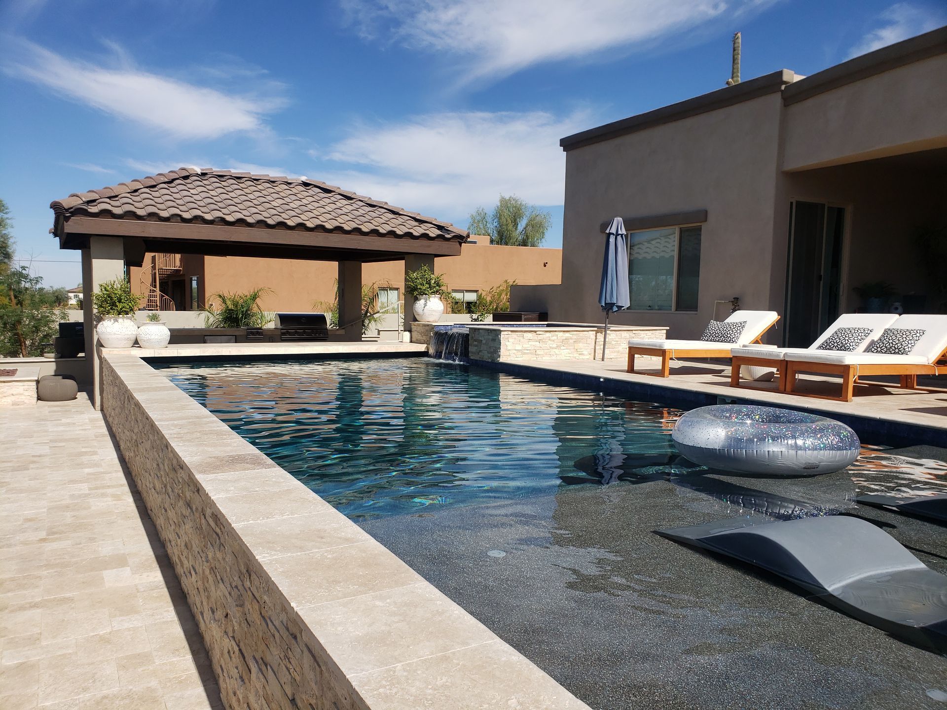 A large swimming pool with a gazebo in the backyard.