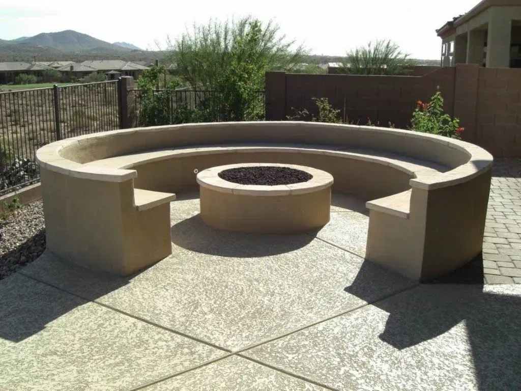 A patio with a fire pit and a curved bench
