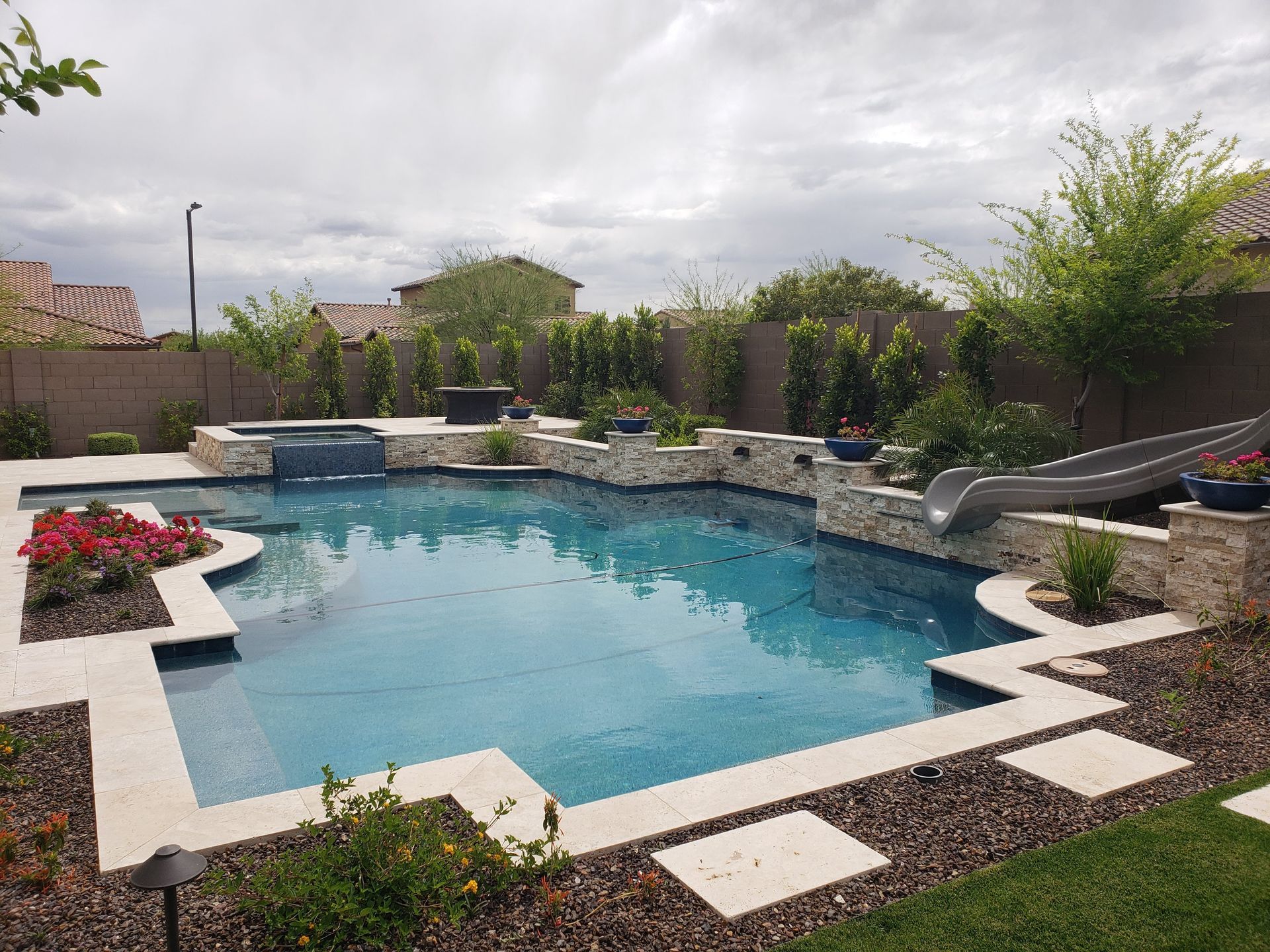 A backyard with a swimming pool and a fire pit