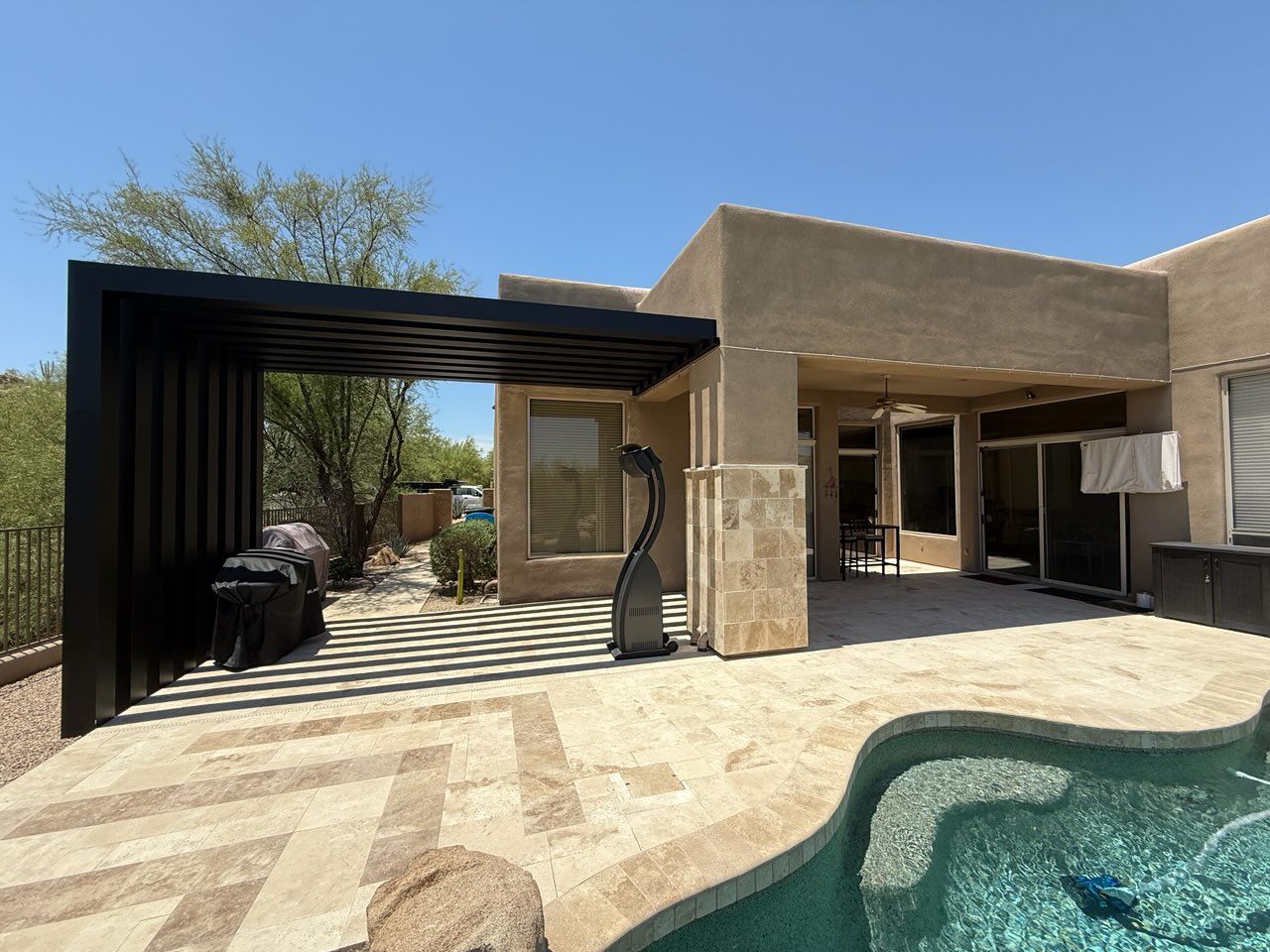 A patio with a table and chairs and a fireplace