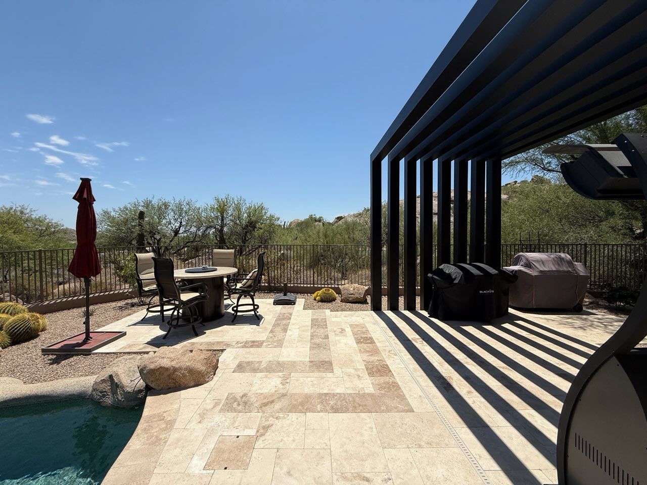 A patio with a pergola and stone steps
