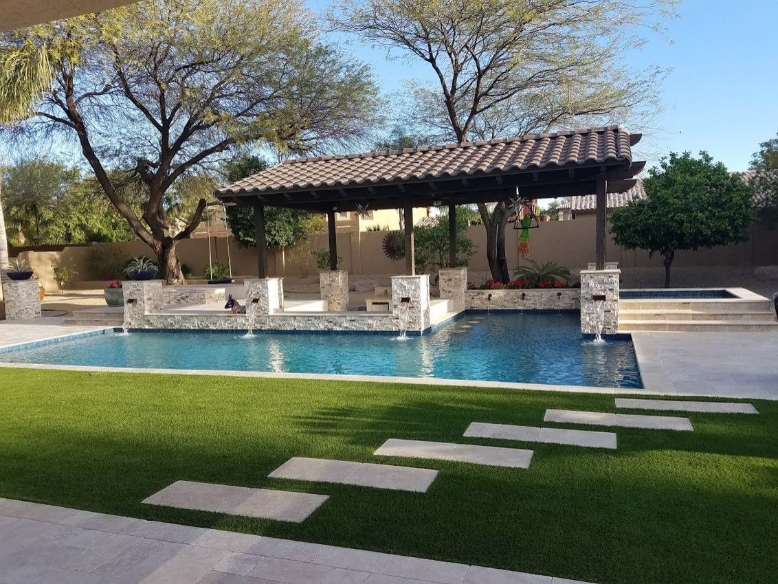 A large swimming pool with a pergola in the background