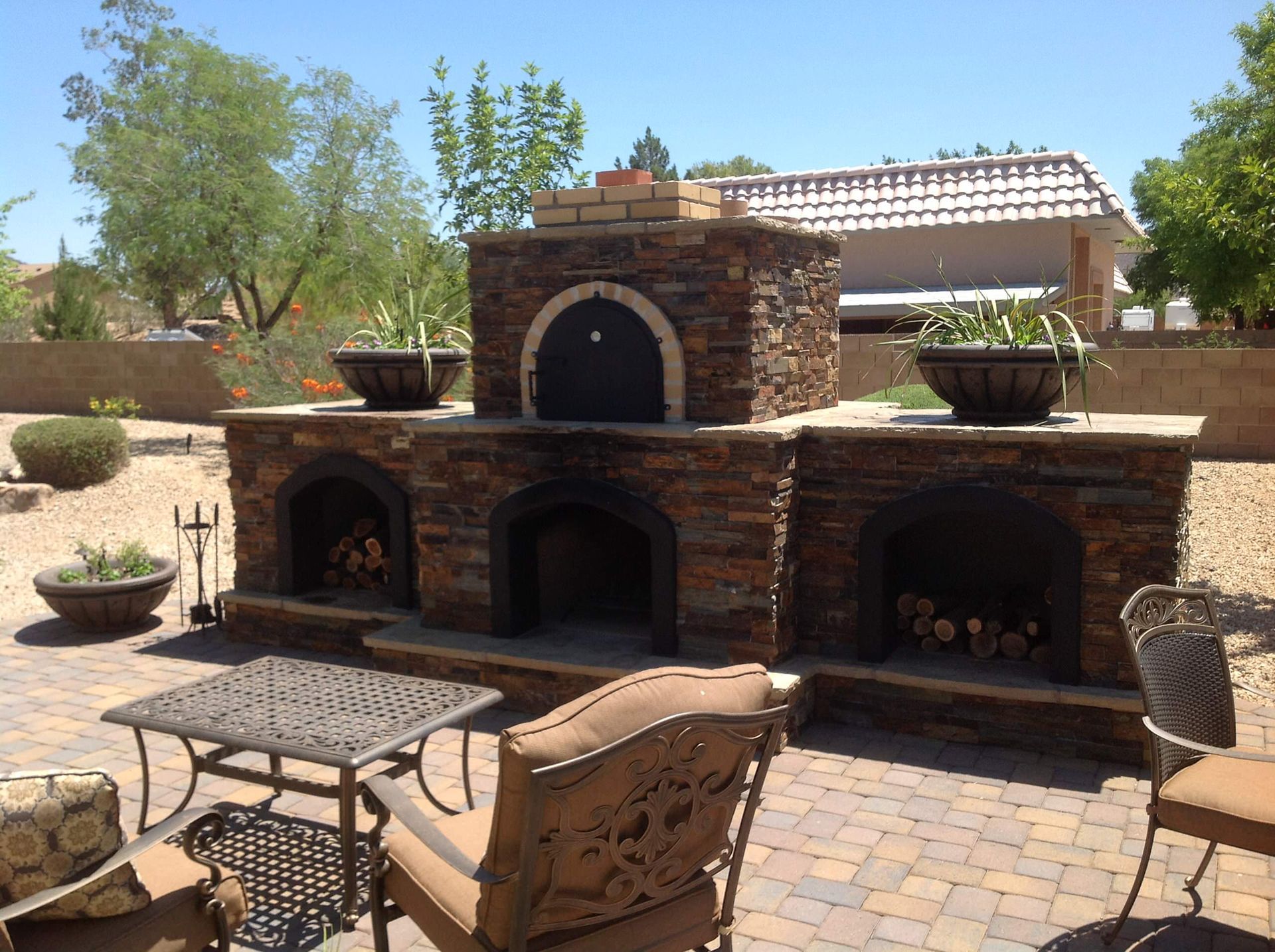 A patio with a fireplace and a table and chairs