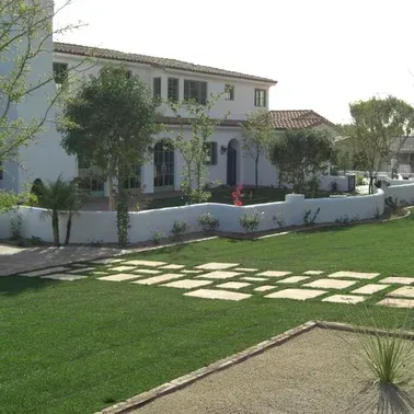 A large white house with a lush green lawn in front of it