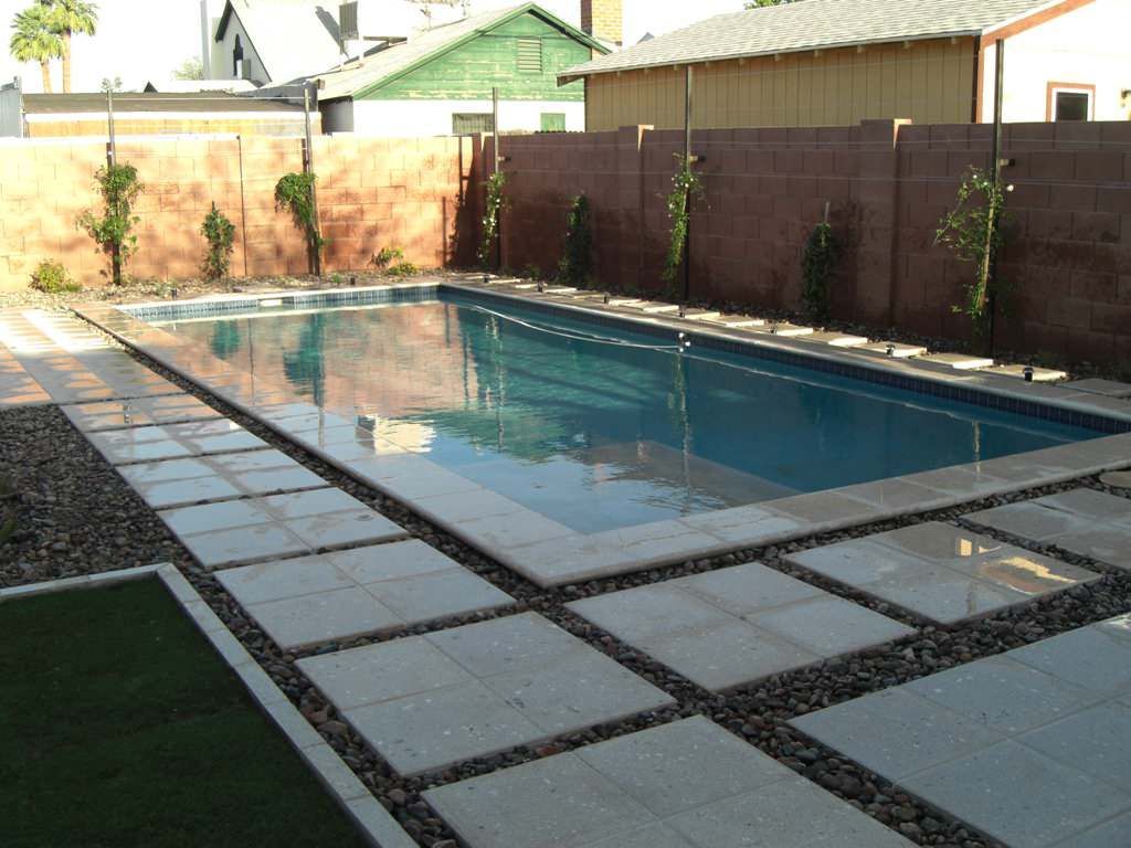 A large swimming pool with a brick fence surrounding it