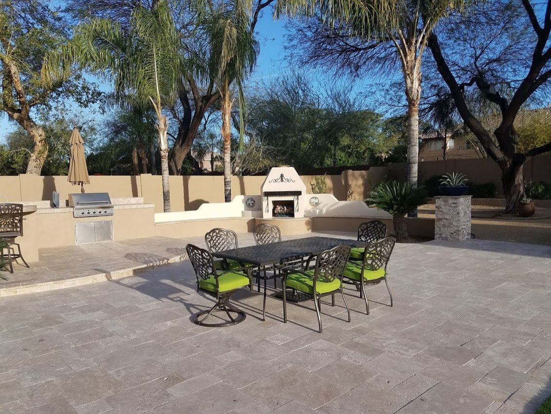 A patio with a table and chairs and a fireplace