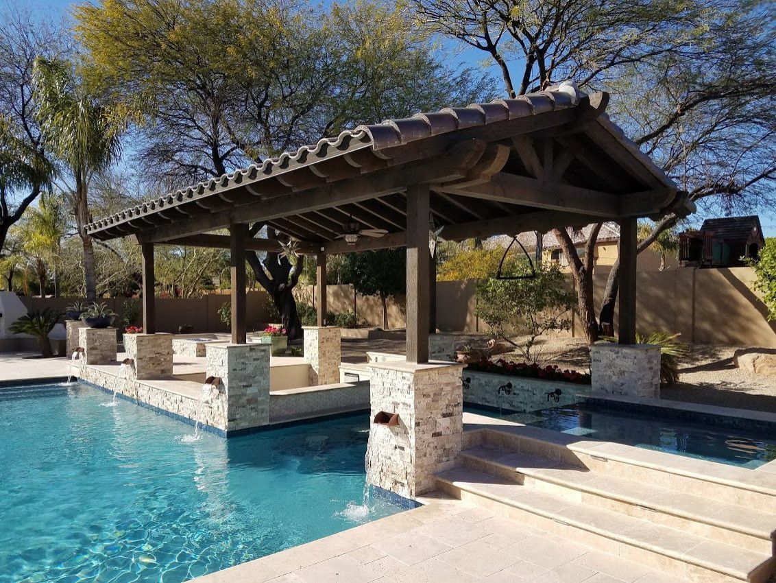 A large swimming pool with a pergola over it.