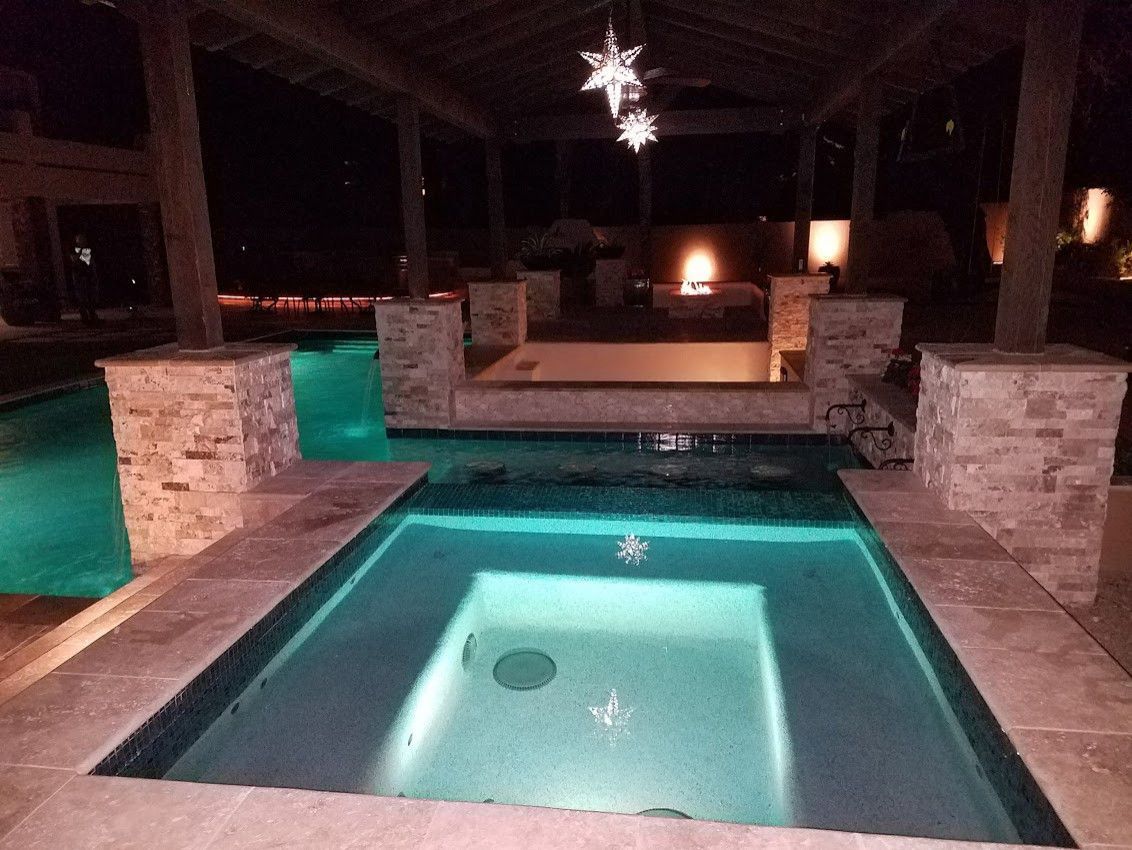 A large swimming pool is lit up at night.