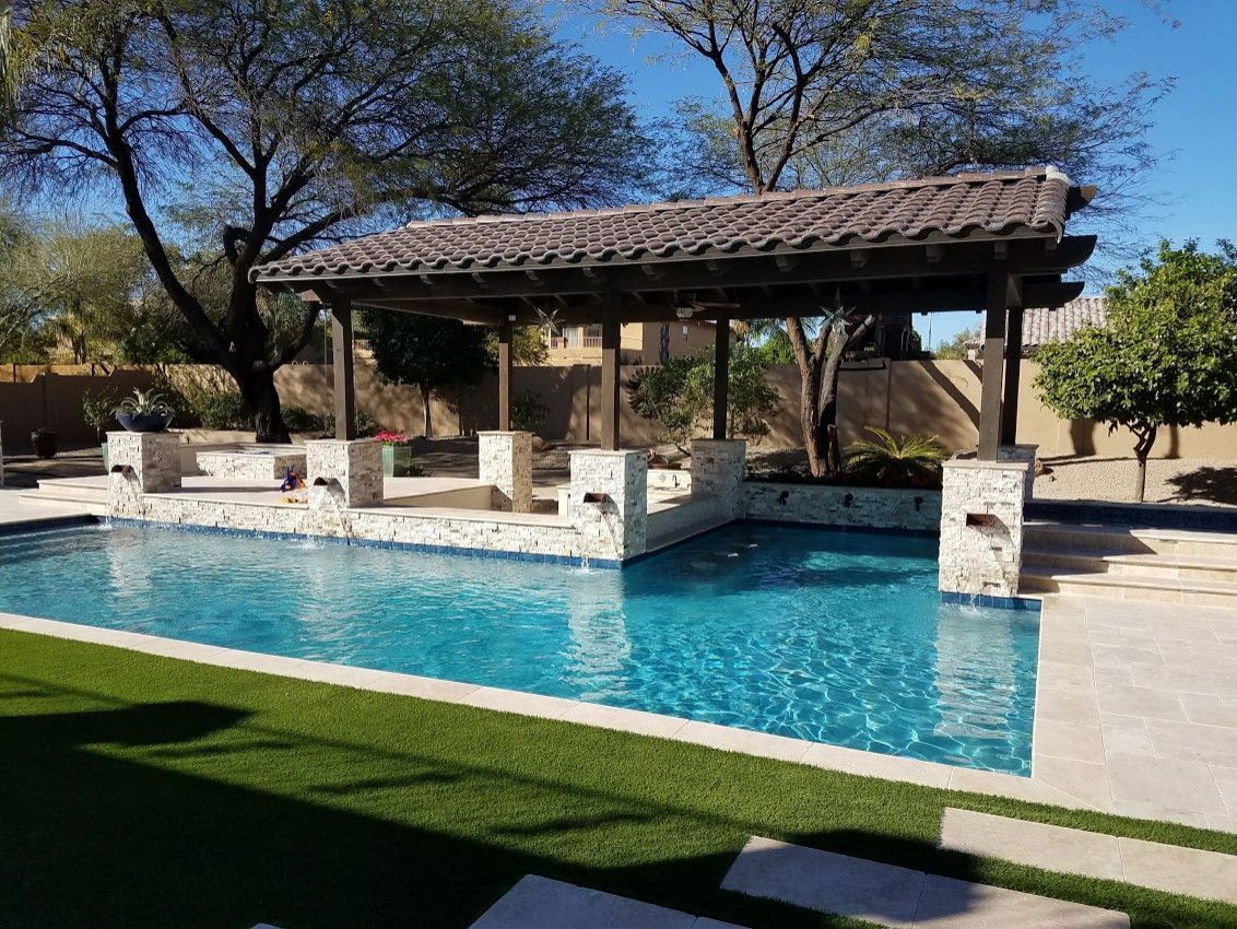 A large swimming pool with a gazebo in the backyard.