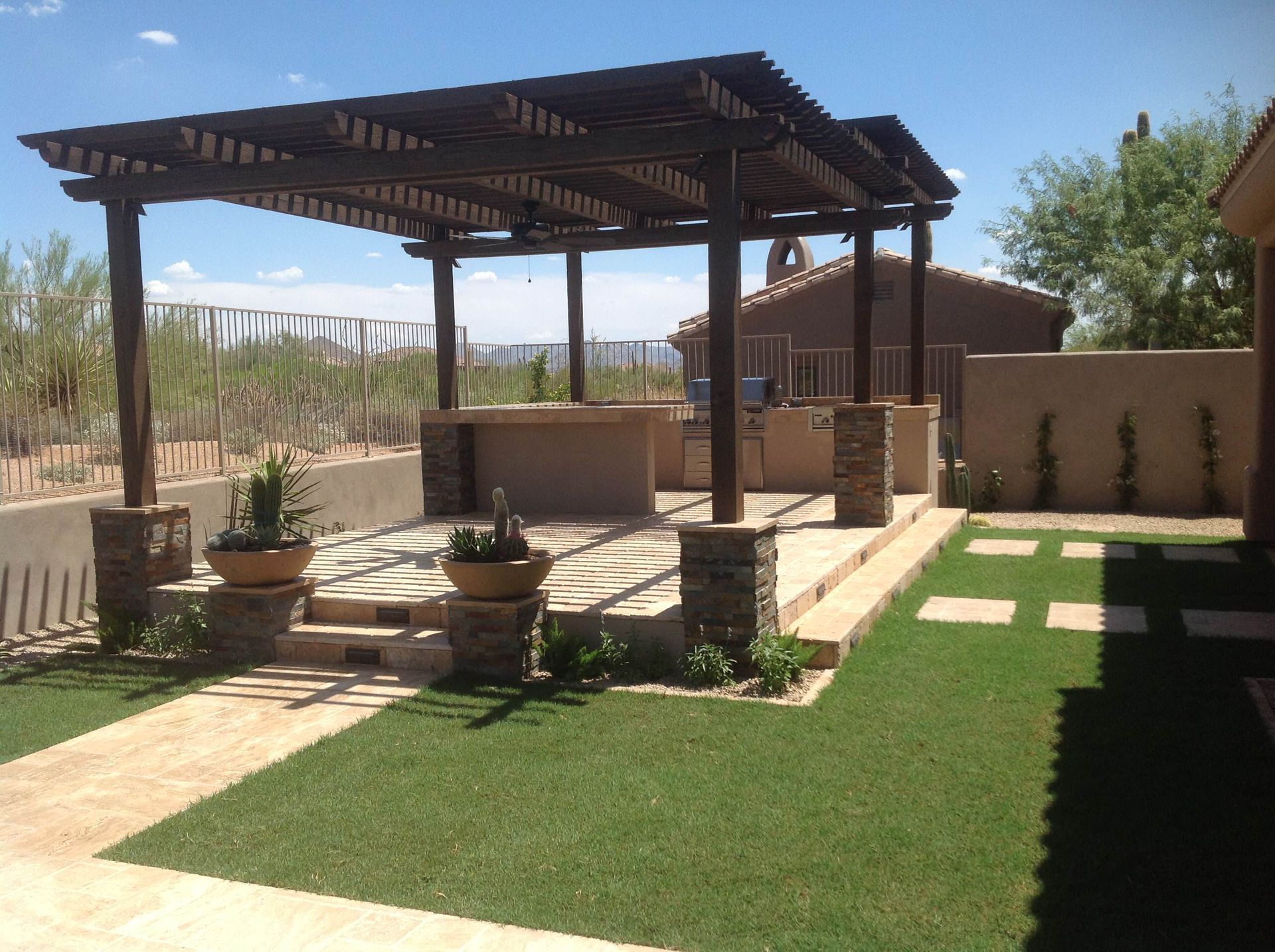 A patio area with a pergola and steps leading to it