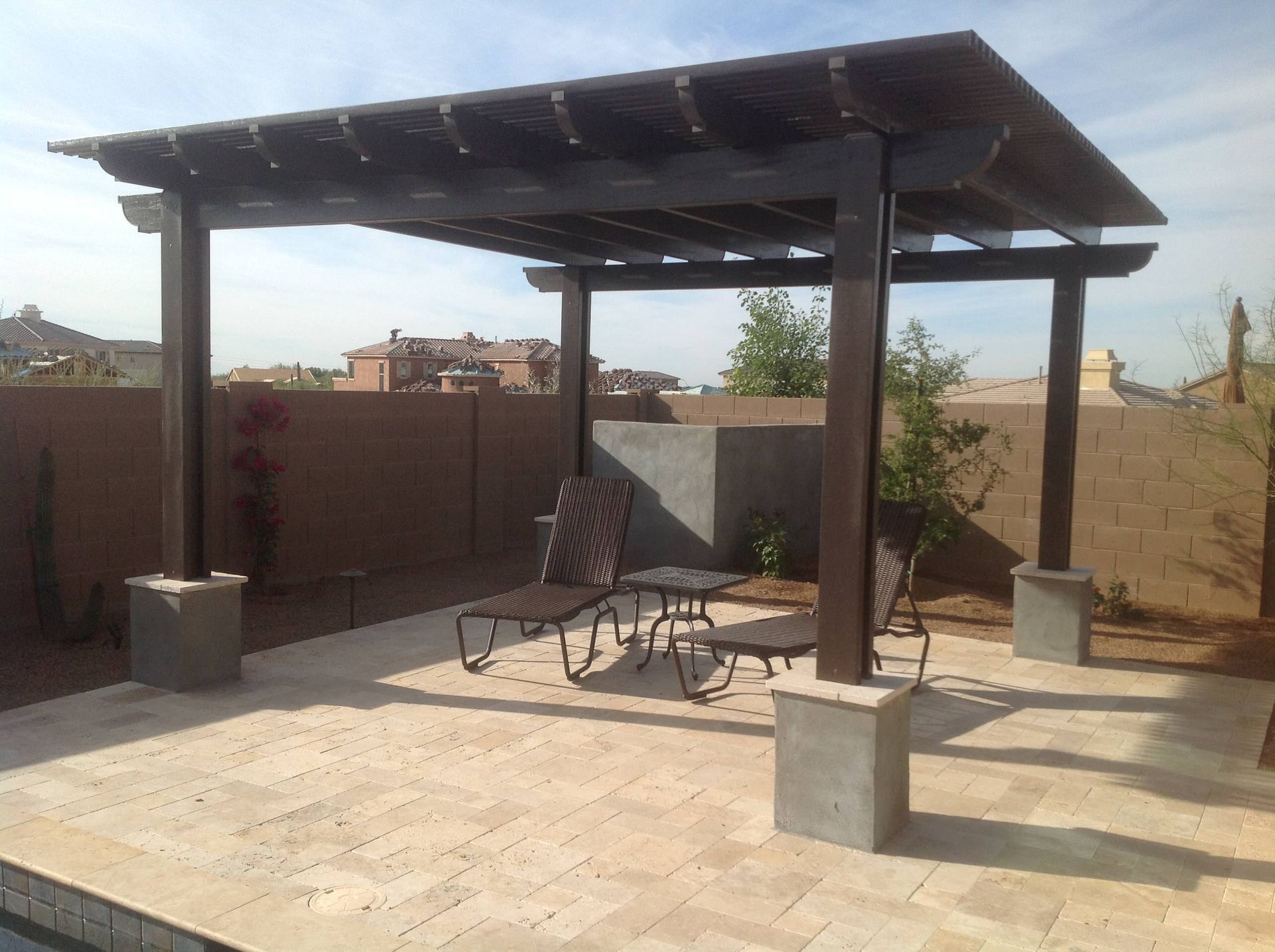 A pergola with a table and chairs underneath it