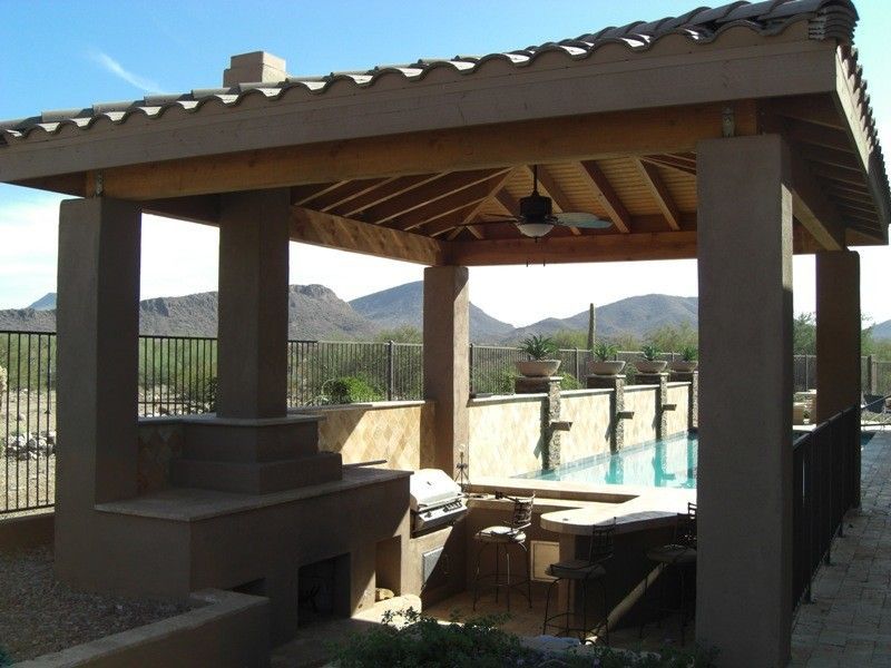 A gazebo overlooking a swimming pool with mountains in the background