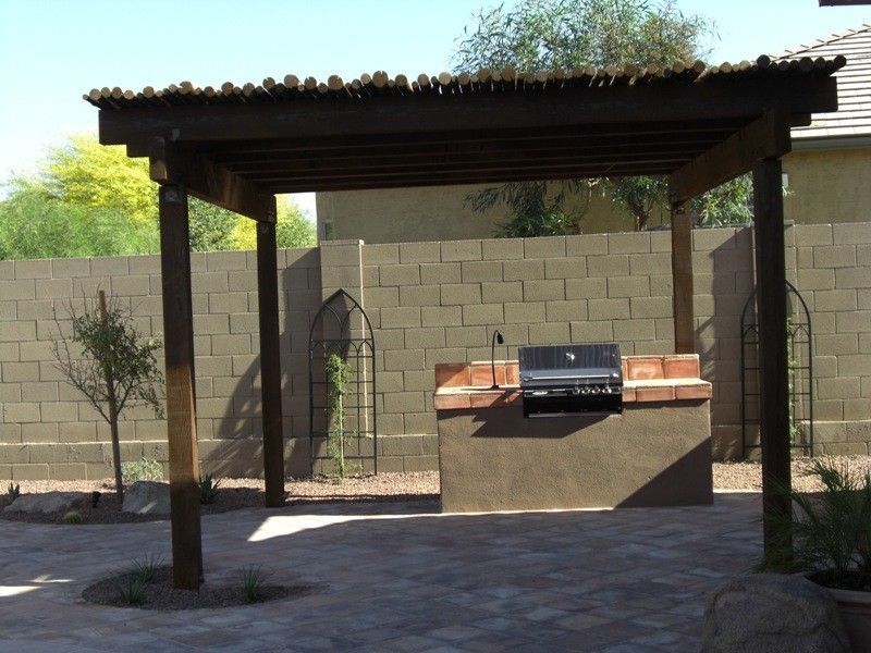A pergola with a grill underneath it