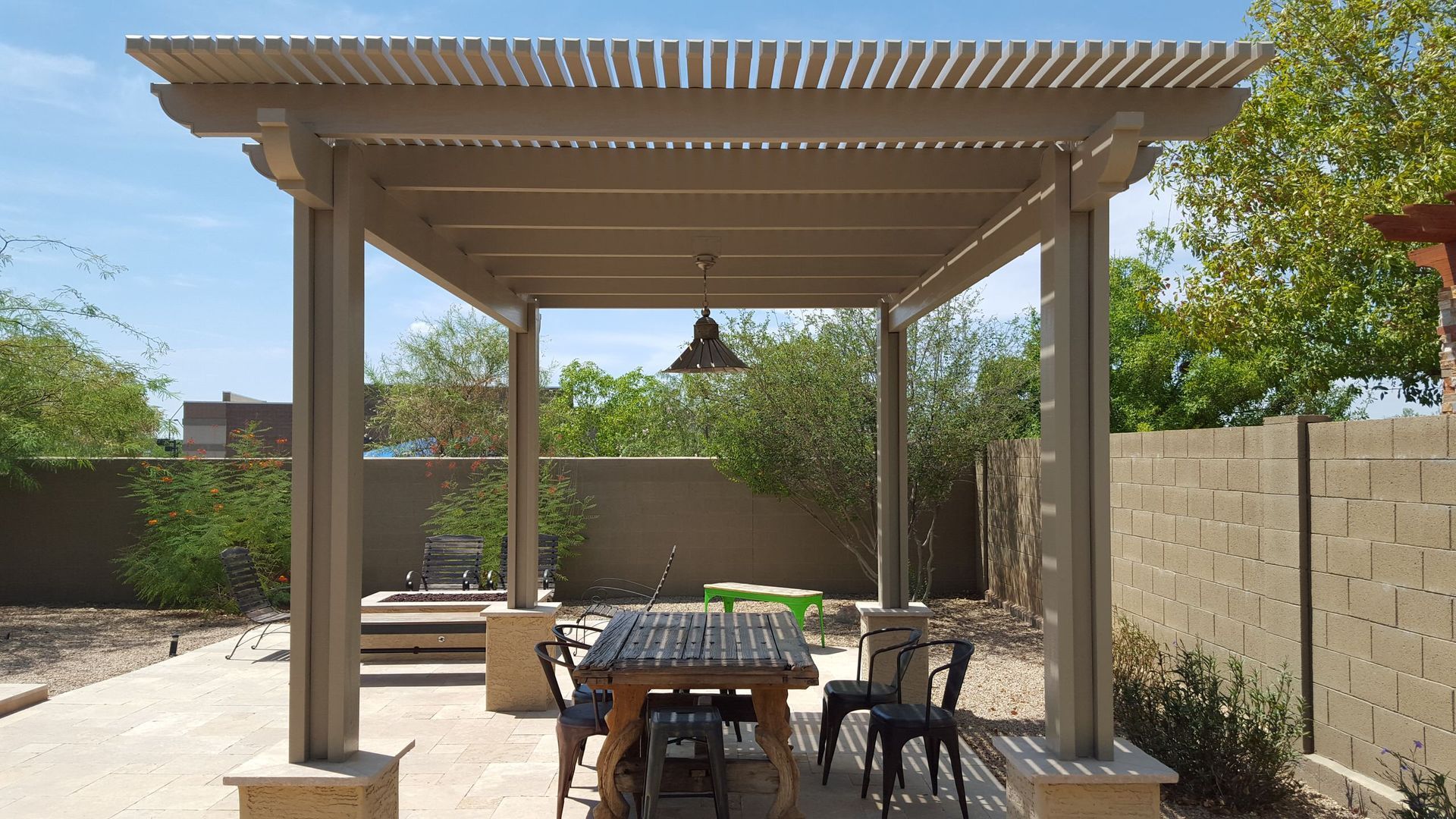 A pergola with a table and chairs underneath it