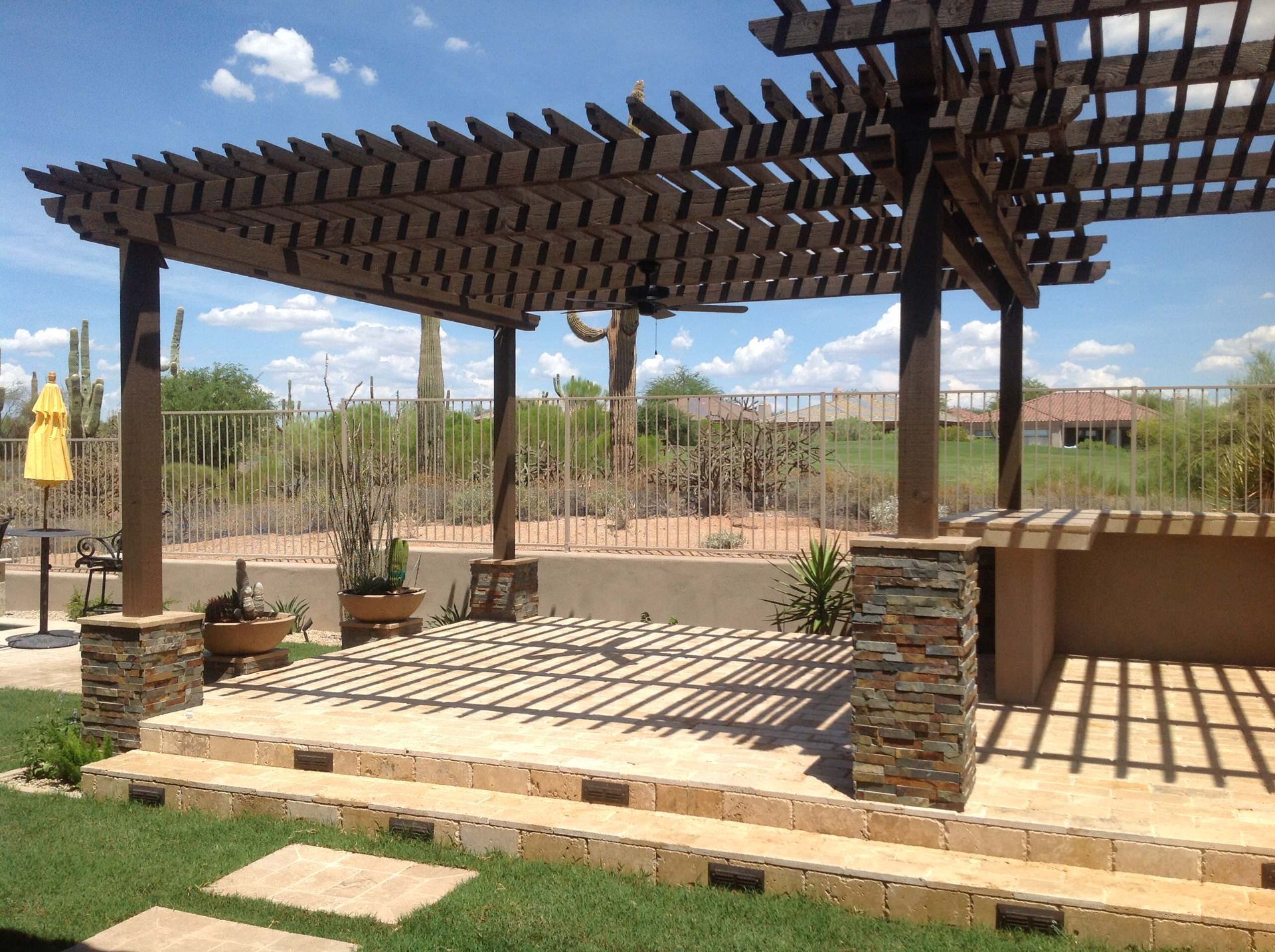 A patio with a pergola and stone steps