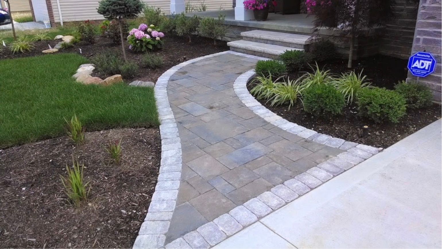 A brick walkway leading to the front door of a house.