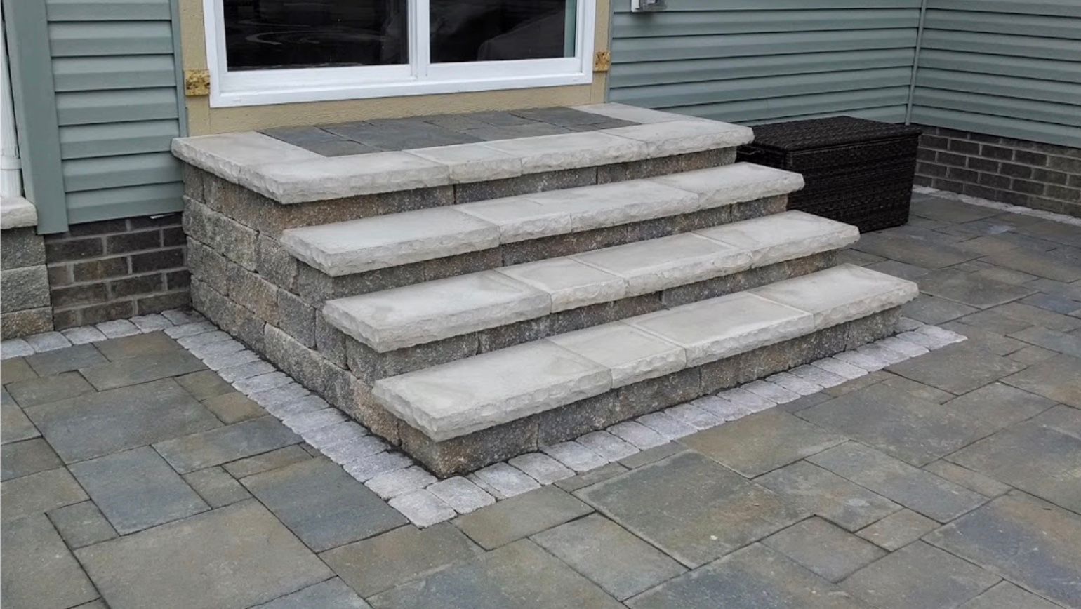 A set of stairs leading up to a house on a patio.