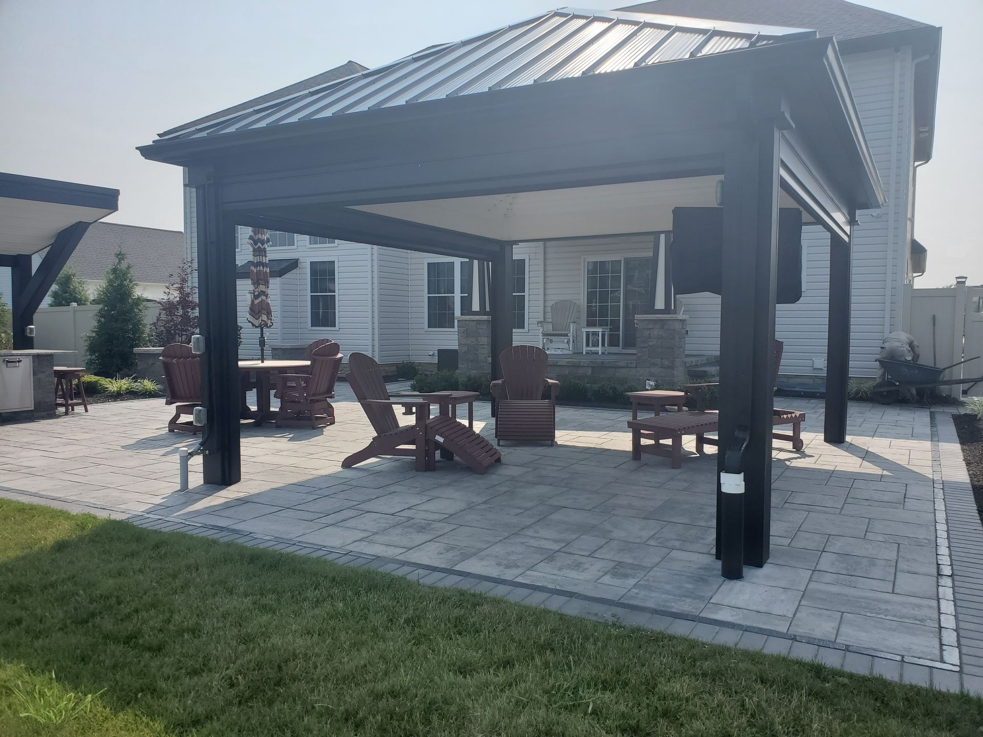 A gazebo with a table and chairs in front of a house.