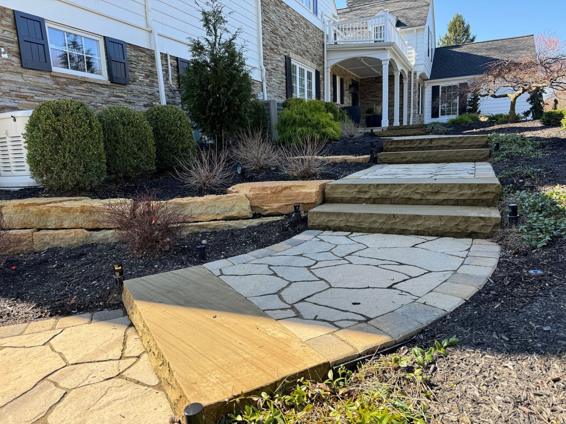 A stone walkway with stairs leading up to a house.