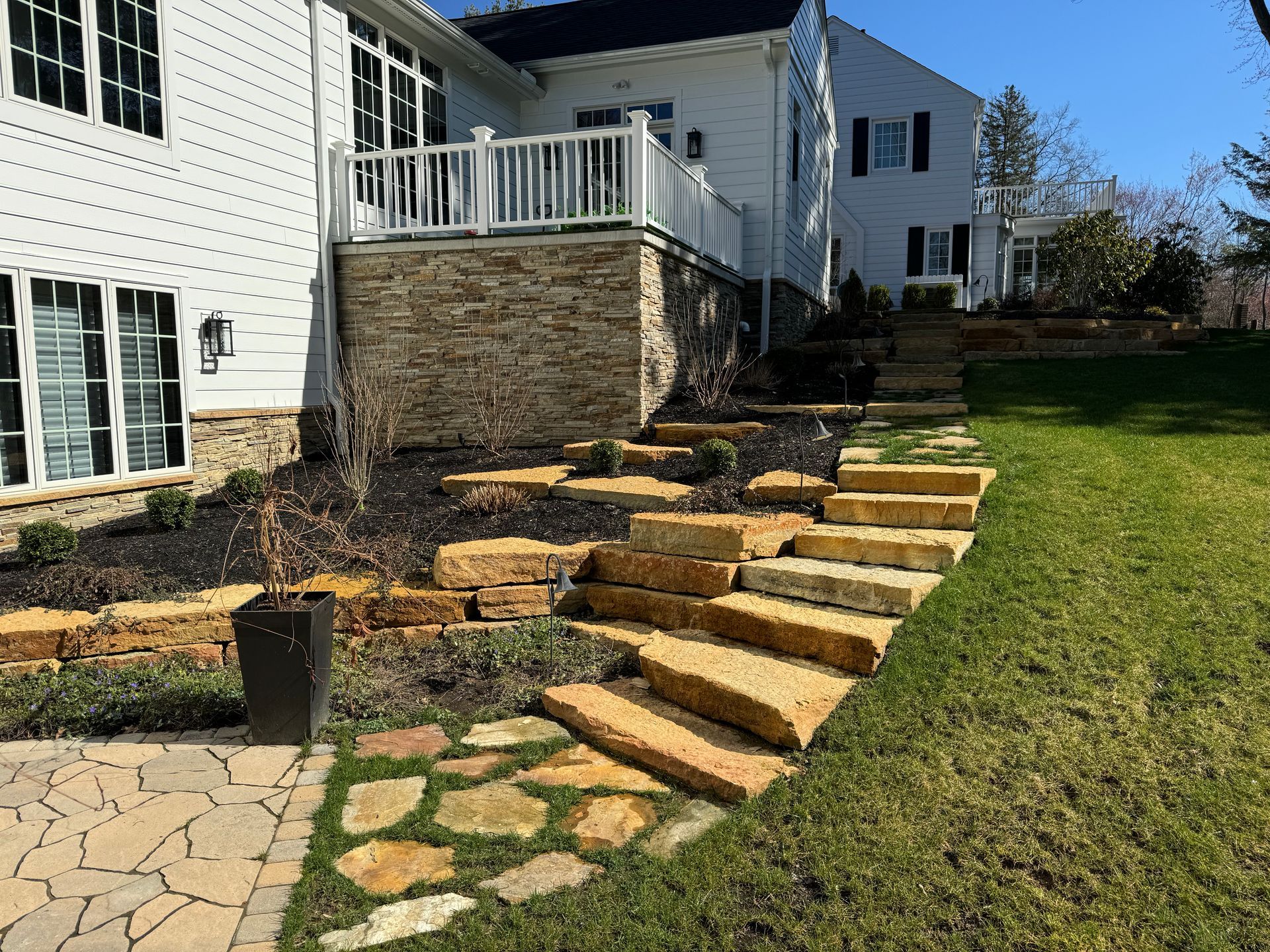 A house with a patio and stairs in front of it.