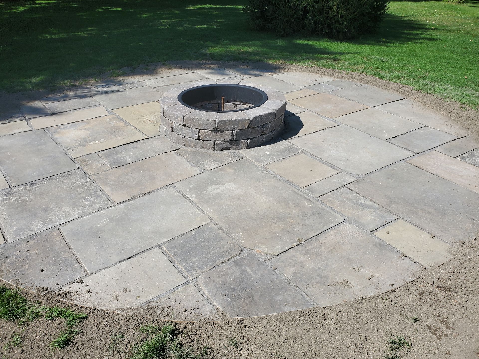 A fire pit is in the middle of a patio