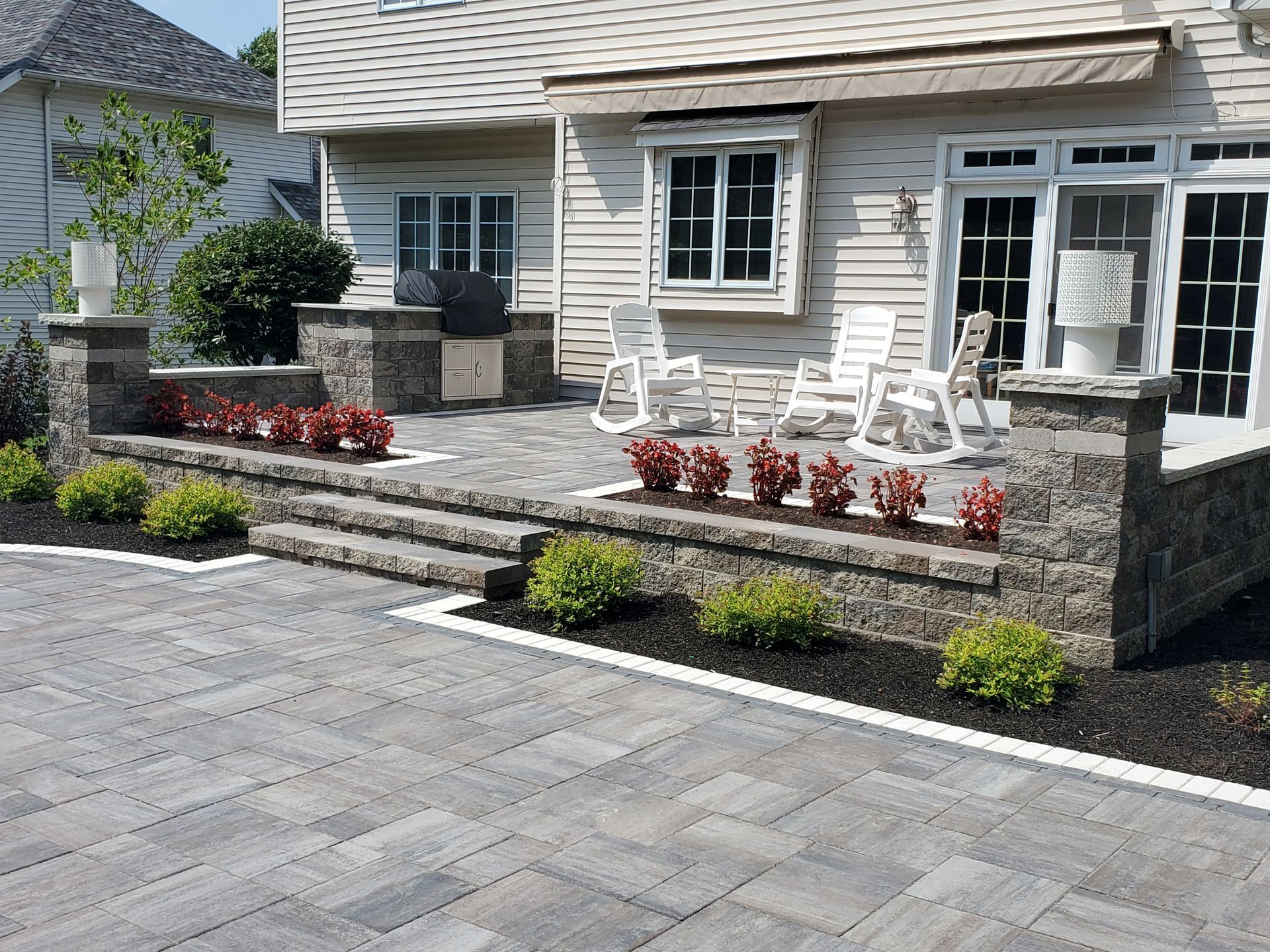 A house with a patio and rocking chairs in front of it