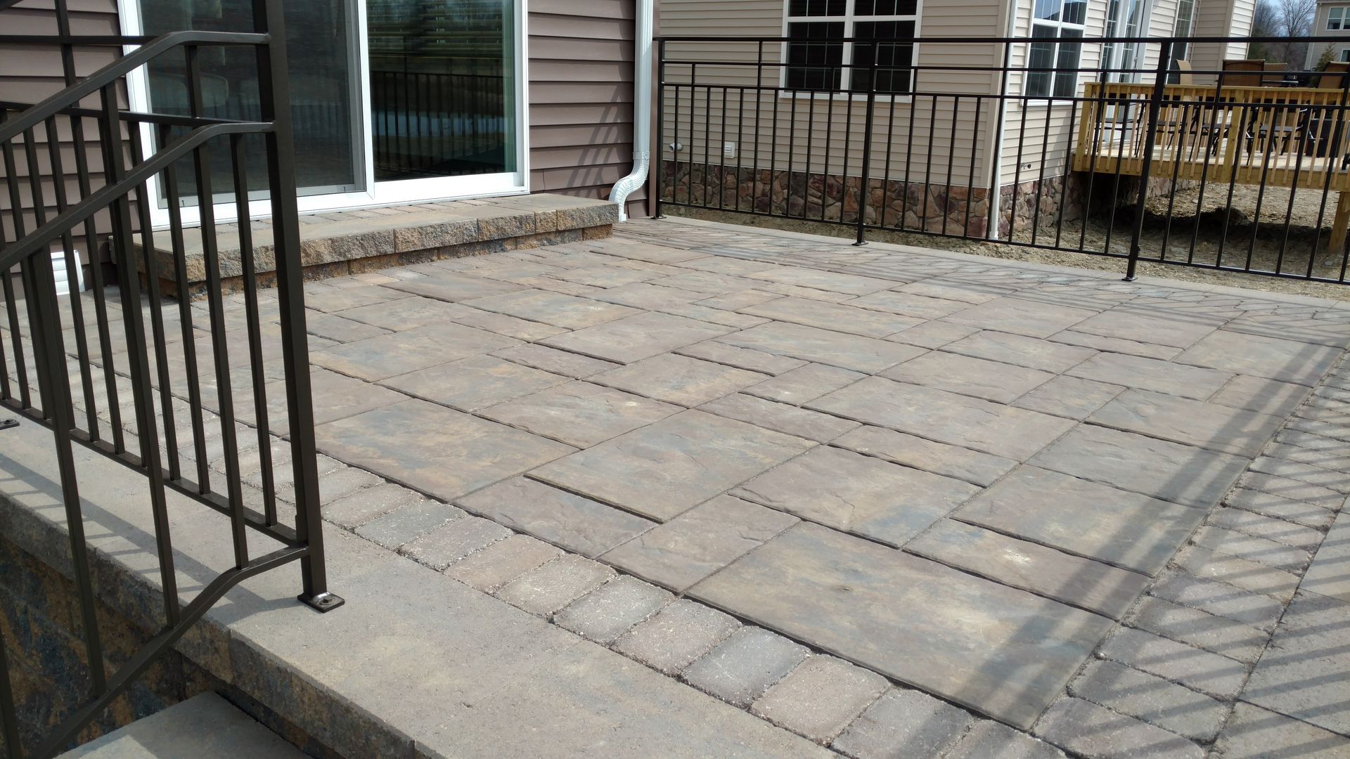 A patio with a railing and stairs leading to it.