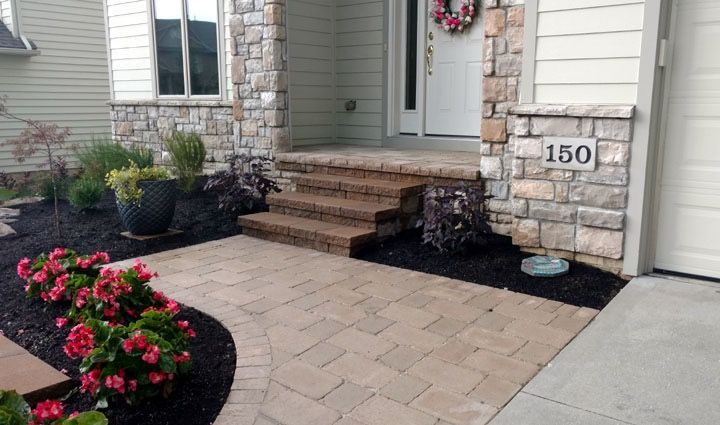 A brick walkway leading to the front door of a house.