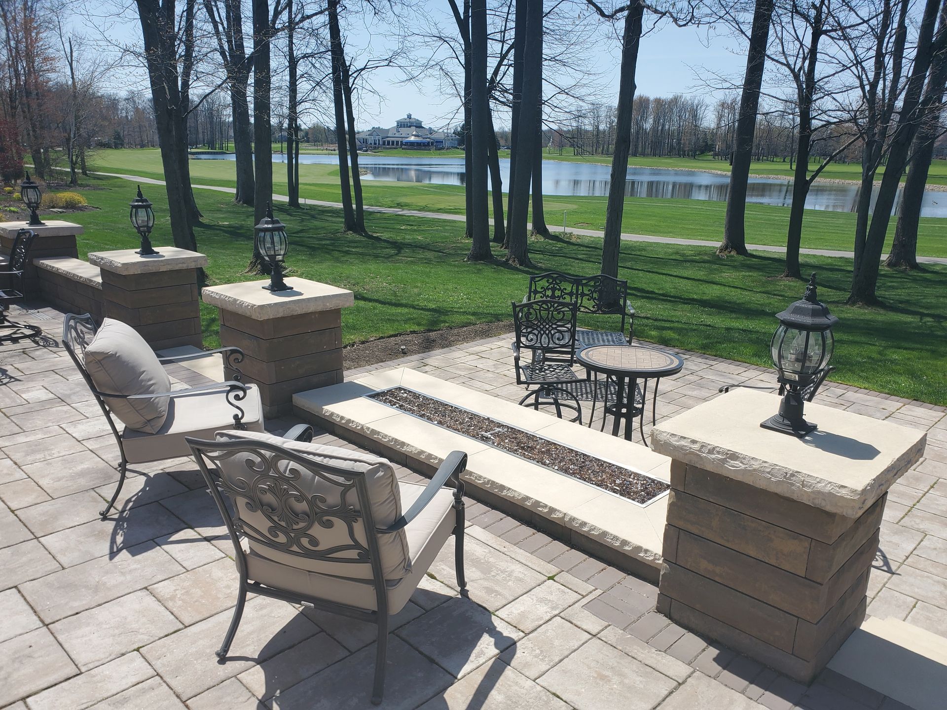 A patio with chairs , a table and a fire pit