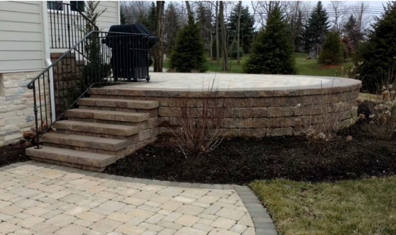 A patio with stairs and a grill on it