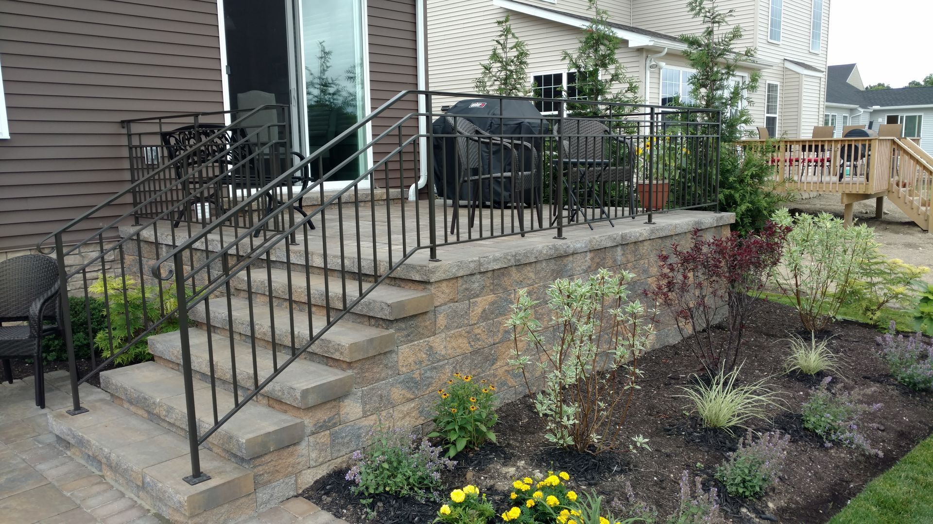 A patio with a wrought iron railing and stairs leading up to it