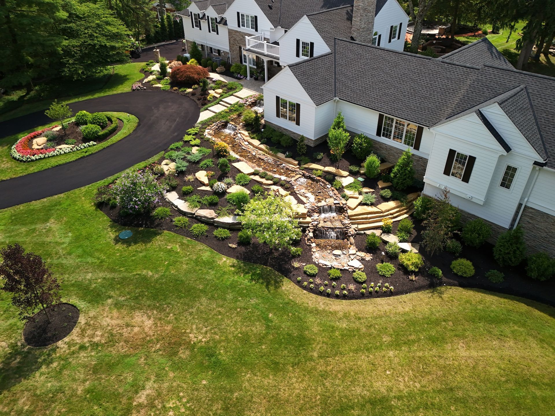 An aerial view of a large white house with a lush green lawn.