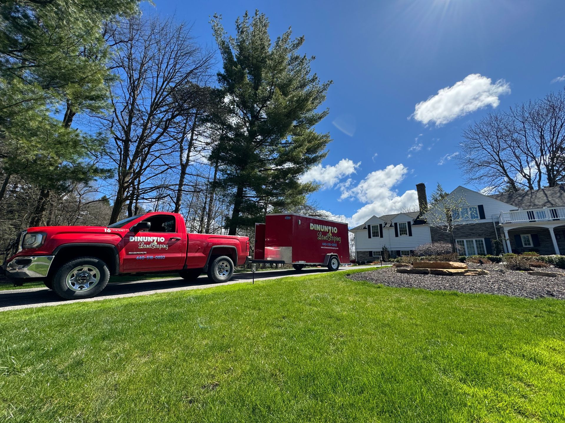 A red truck is parked on the side of the road next to a trailer.