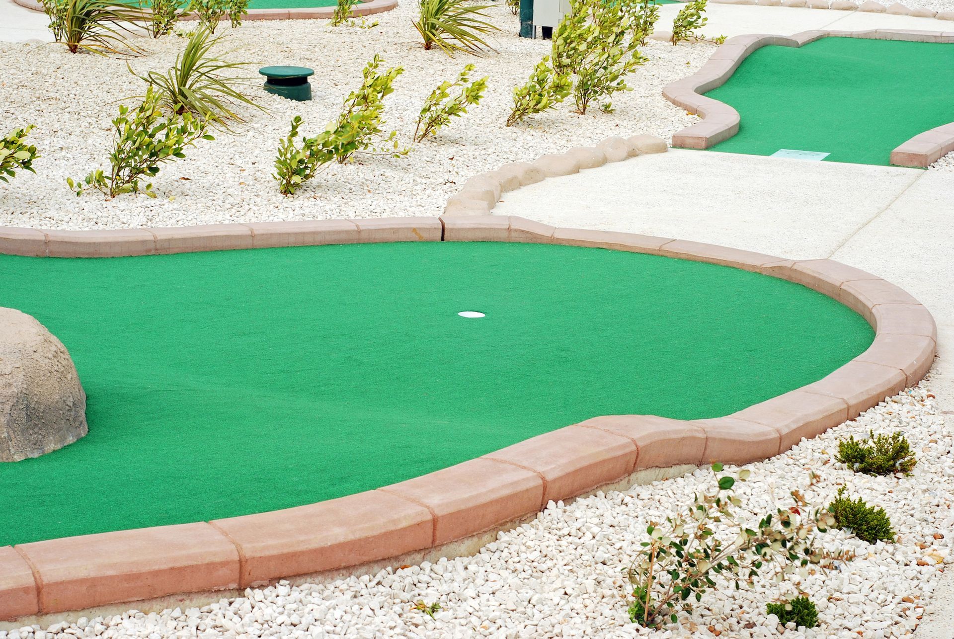 A mini golf course with a white ball on the green