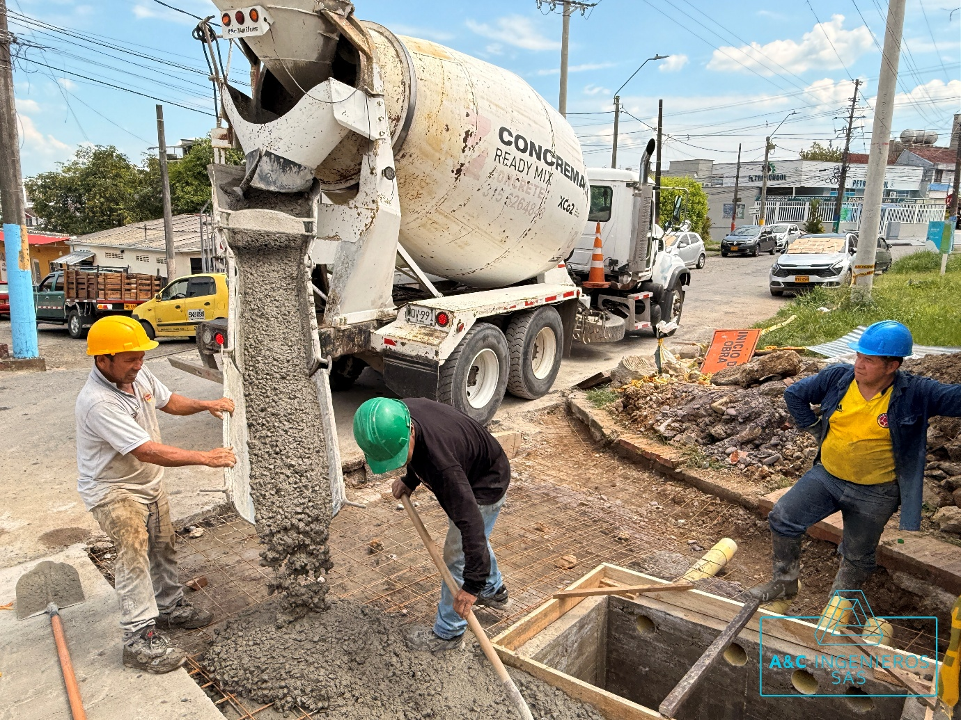 Trabajadores vierten hormigón desde un camión hormigonera en una obra en construcción.