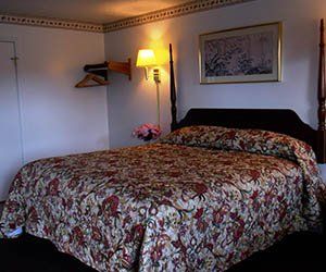 bed with floral cover -Motel in Pittsburgh, PA