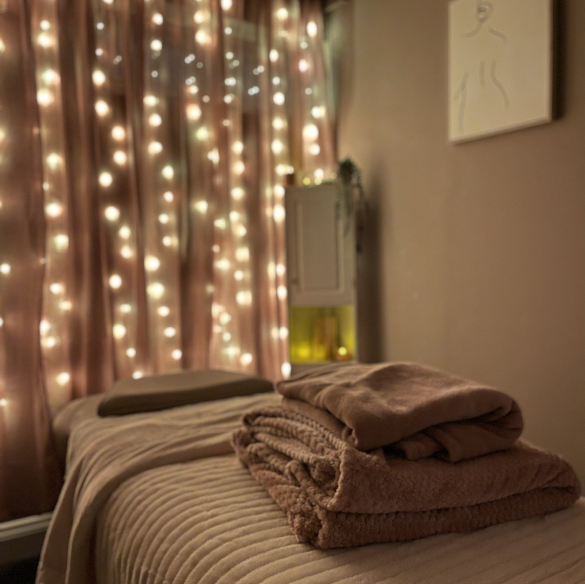 A treatment bed with towels and fairy lights