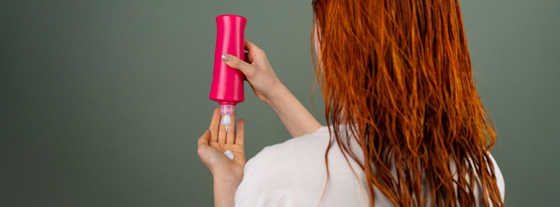 Person applying a hair mask to red hair